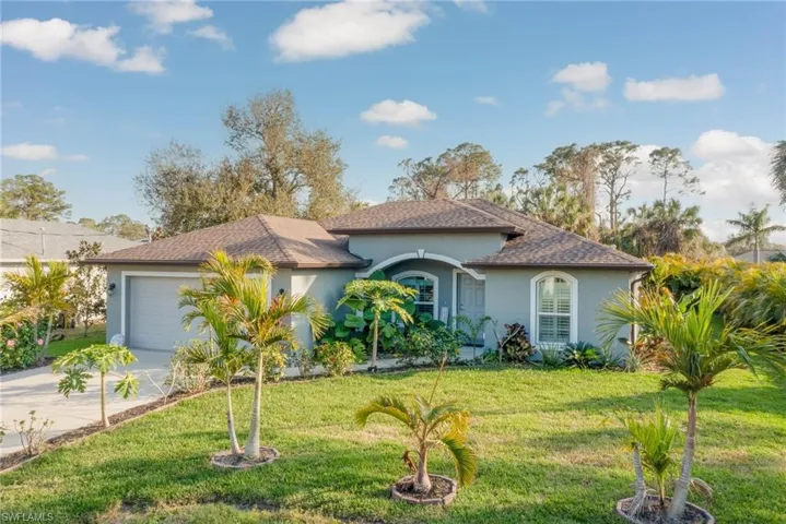 View of front of property featuring a garage and a front lawn