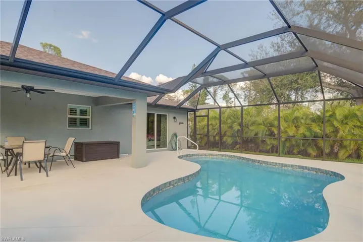 View of pool featuring ceiling fan, a lanai, and a patio area