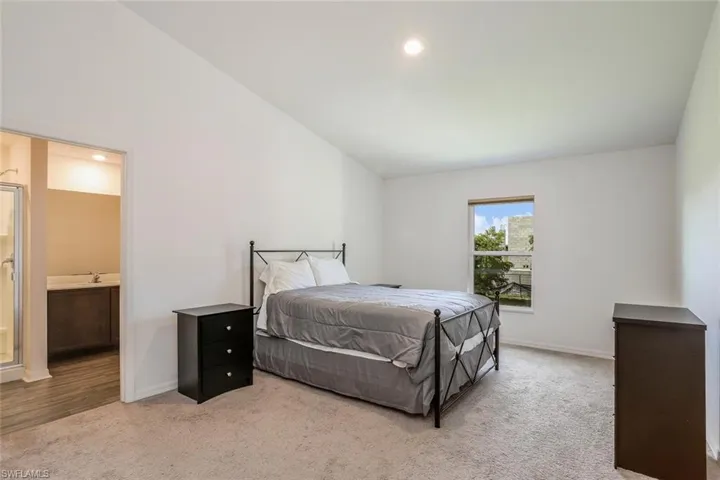Carpeted room with a window, showcasing a neutral color palette and recessed lighting