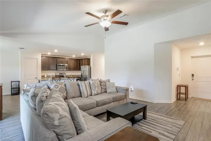 Open-concept living area featuring wood-finish flooring, a ceiling fan, and recessed lighting