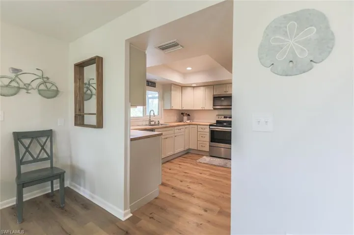 Kitchen with light hardwood / wood-style floors, appliances with stainless steel finishes, and sink