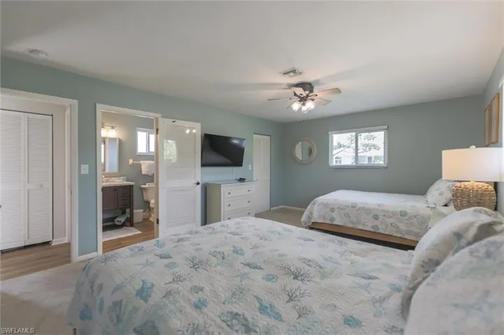 Bedroom with ceiling fan, ensuite bath, and light hardwood / wood-style floors