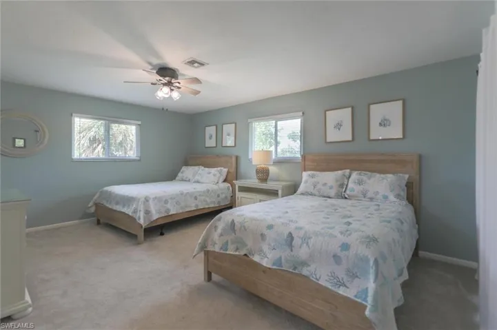 Carpeted bedroom featuring ceiling fan