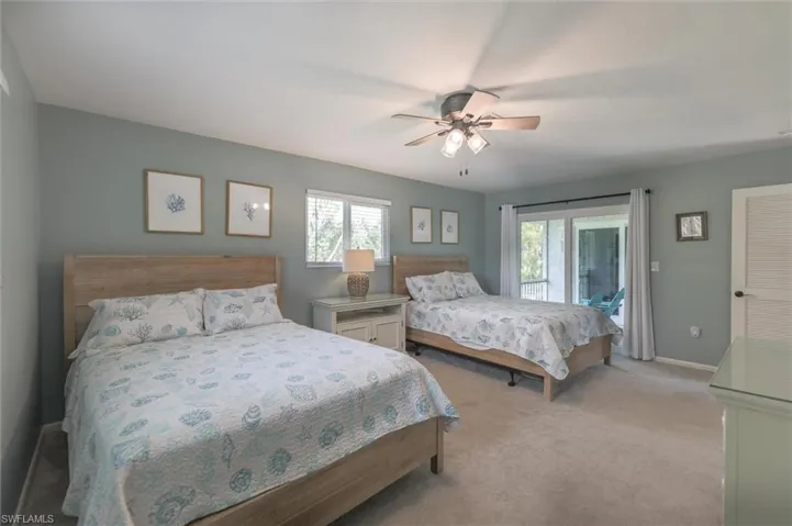 Bedroom featuring ceiling fan, light carpet, and access to outside