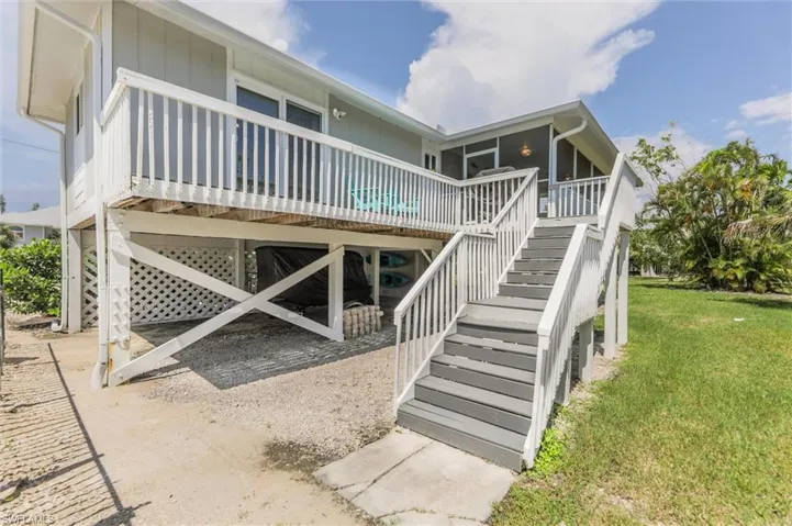 Rear view of property with a deck and a yard
