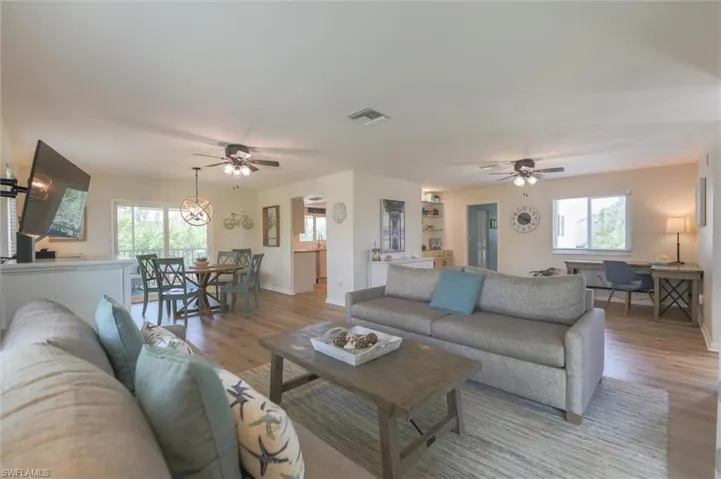 Living room featuring light hardwood / wood-style floors, ceiling fan, and plenty of natural light