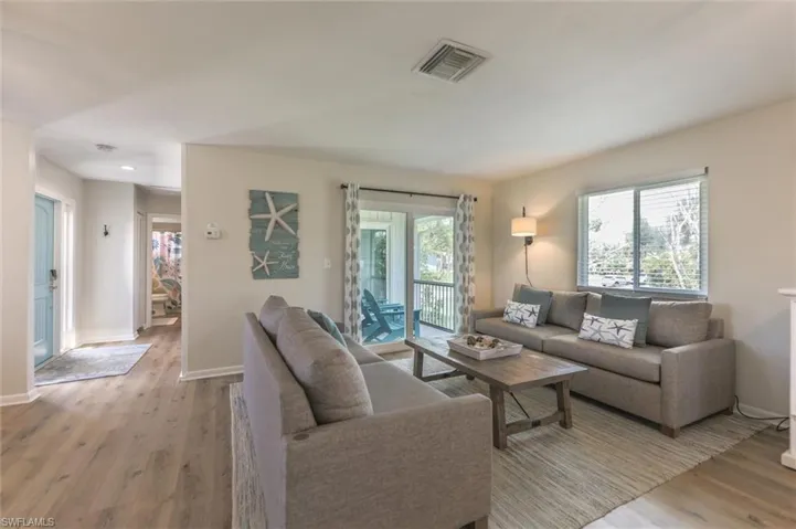 Living room with light hardwood / wood-style floors and a healthy amount of sunlight