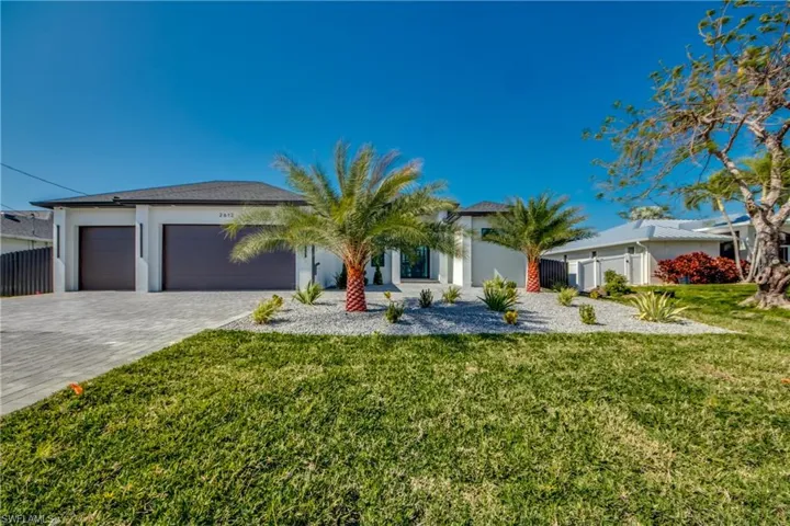Ranch-style home featuring a garage and a front lawn