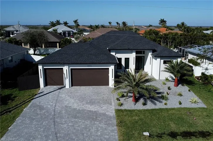 View of front of house featuring a garage, a residential view, decorative driveway, and a front lawn