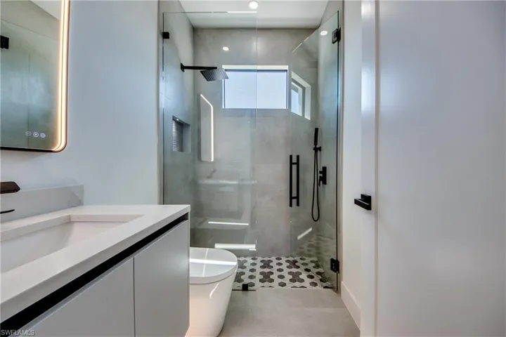 Bathroom featuring vanity, tile patterned flooring, toilet, and walk in shower