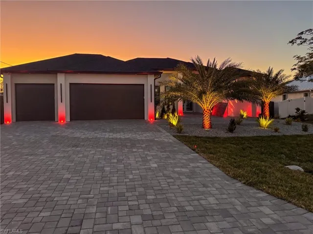 View of front of property with a garage and a lawn
