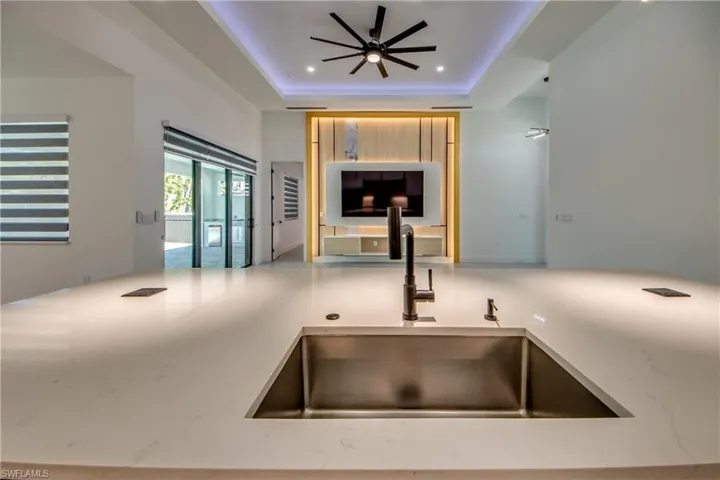 Kitchen with ceiling fan, a tray ceiling, and sink