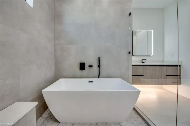 Bathroom featuring vanity and a washtub