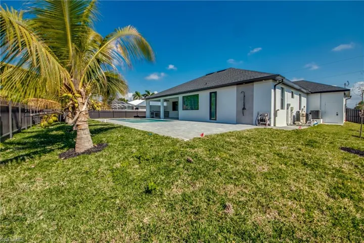 Back of house with a patio area and a lawn