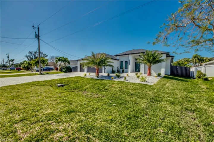 View of front of house with a garage and a front lawn