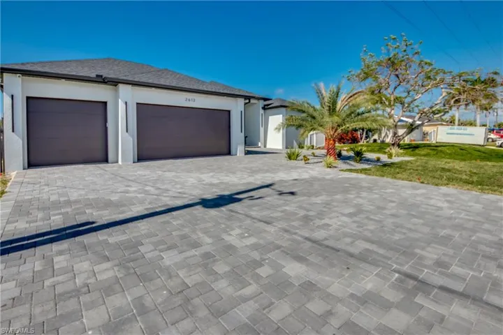 View of front of home with a garage and a front lawn