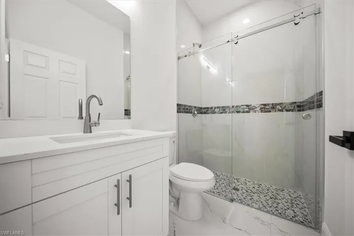 Full bathroom with a marble finish shower, vanity, and marble finish floors