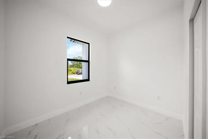 Unfurnished room featuring baseboards and marble finish floors