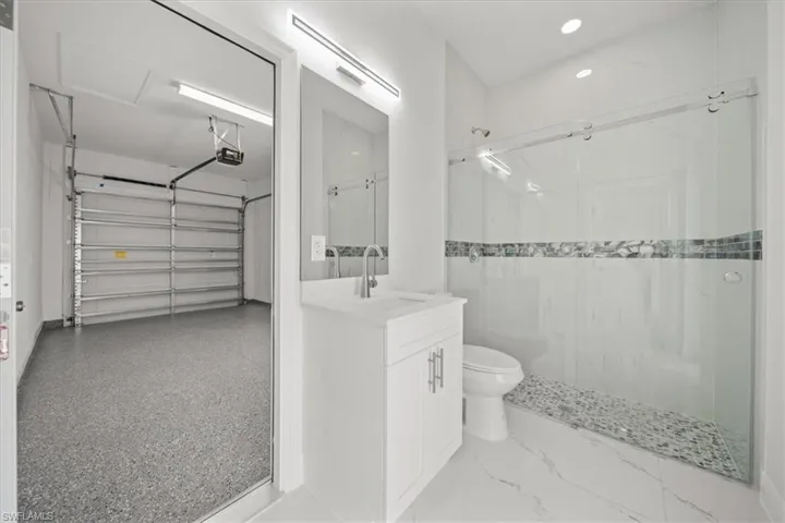 Full bath with vanity, a marble finish shower, and a walk in closet