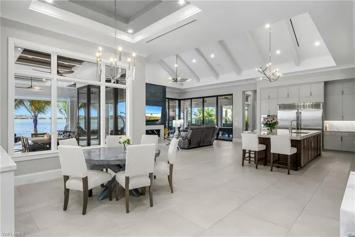Dedicated dining space with lighted coffered ceiling and custom lighting is just steps from the gourmet custom kitchen.