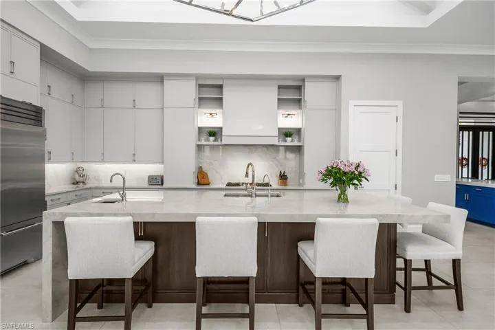 Kitchen includes custom 3" leathered finish quartz waterfall countertop, two Bosch dishwashers, Dual True professional grade refrigerator/freezer, Blue Star professional grade gas range, Stainless steel sink with additional vegetable prep sink.