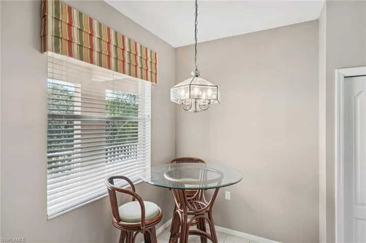 Tiled dining room featuring a chandelier and baseboards
