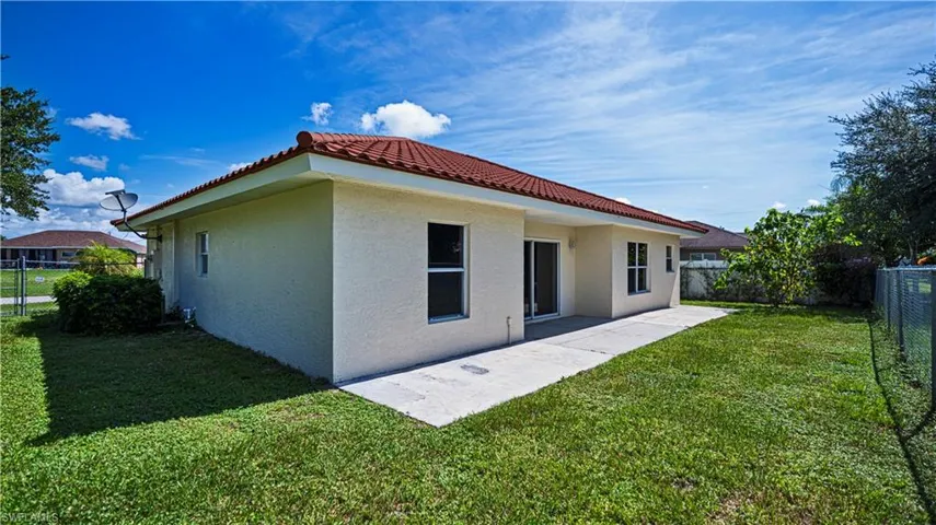 Rear view of property with a yard