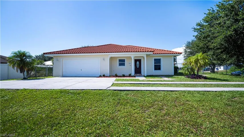Mediterranean / spanish-style home with a garage and a front yard