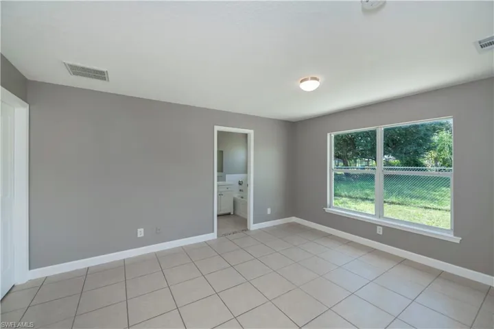 Tiled empty room with a healthy amount of sunlight
