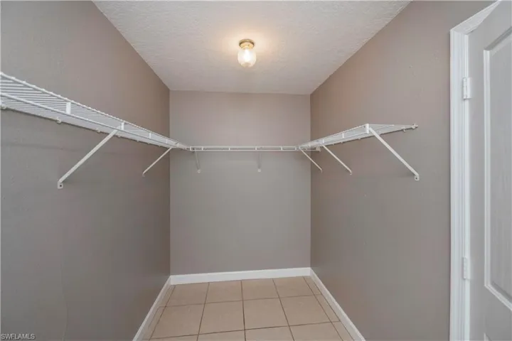 Walk in closet with light tile patterned flooring