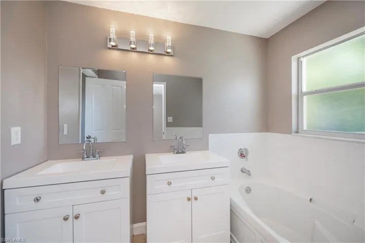 Bathroom with a washtub and double vanity