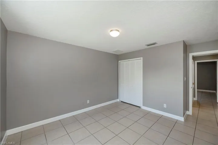 Unfurnished bedroom featuring a closet and light tile patterned floors