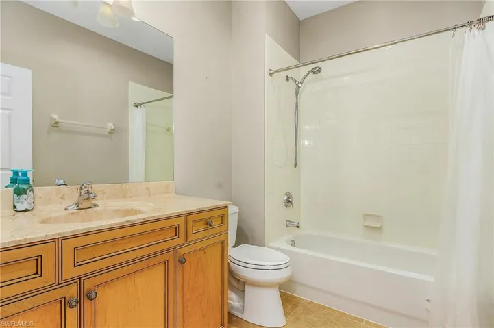 Full bathroom featuring vanity, toilet, shower / bathtub combination with curtain, and tile patterned floors