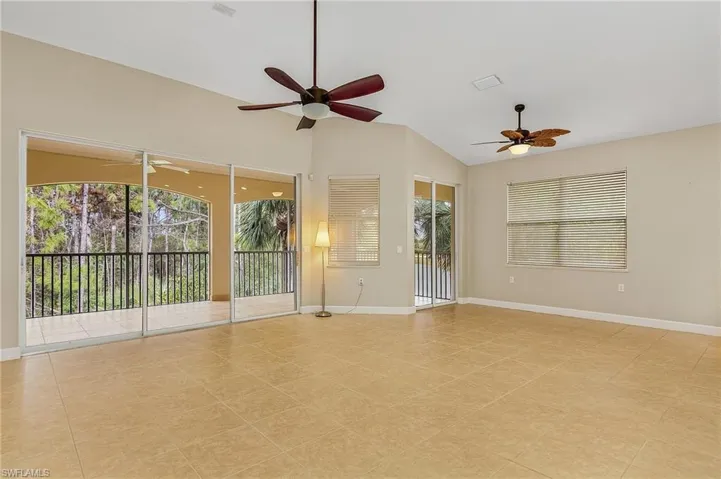 Spare room with vaulted ceiling, ceiling fan, and light tile patterned flooring