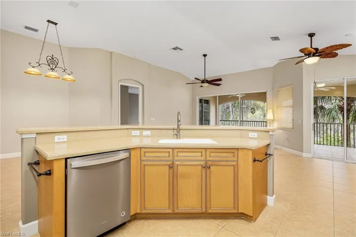 Kitchen featuring ceiling fan, a kitchen island with sink, and stainless steel dishwasher
