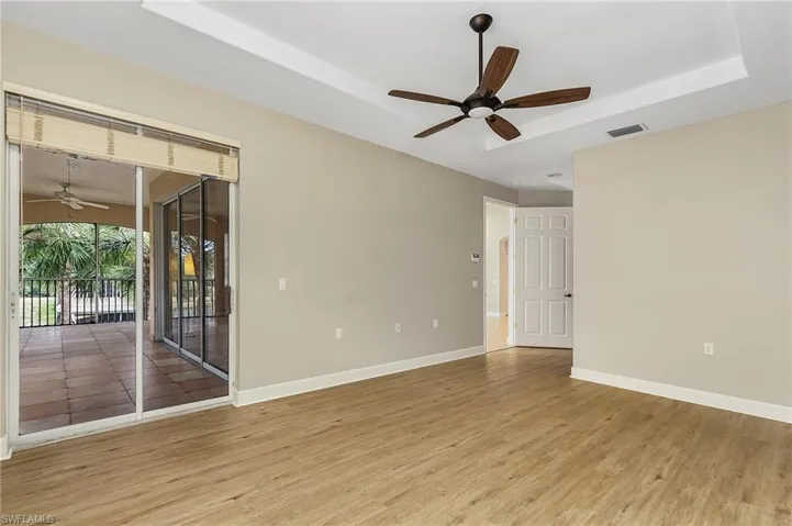 Spare room with ceiling fan, a raised ceiling, and hardwood / wood-style floors