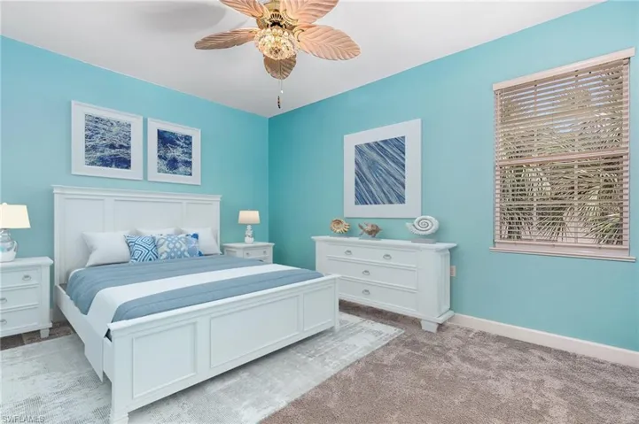 Carpeted bedroom featuring ceiling fan