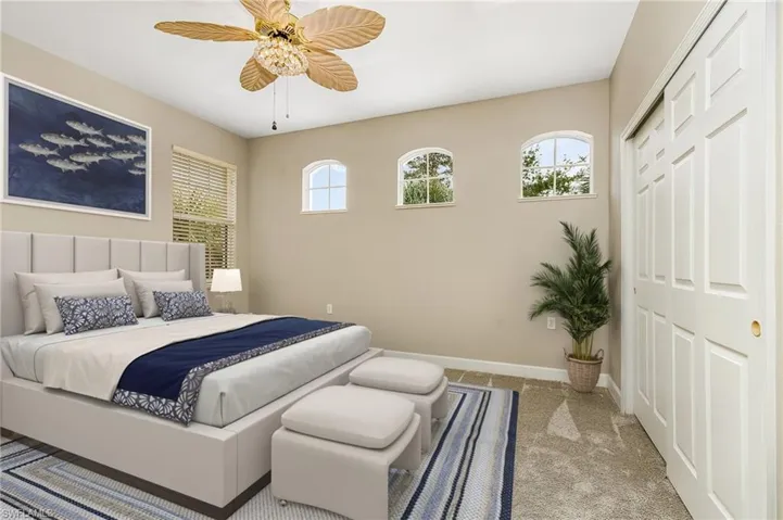 Bedroom with light carpet, a closet, multiple windows, and ceiling fan
