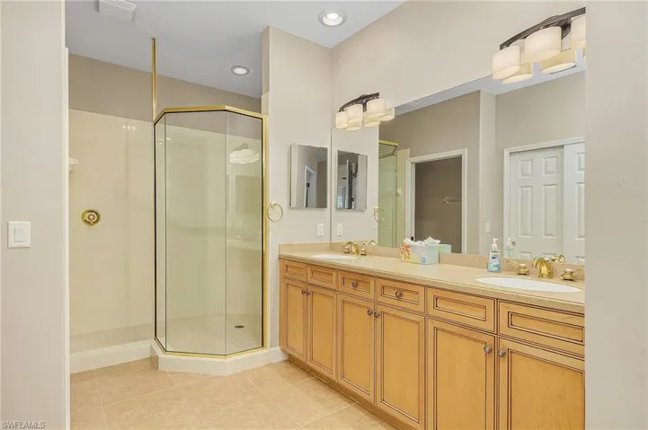 Bathroom with vanity, tile patterned flooring, and a shower with door