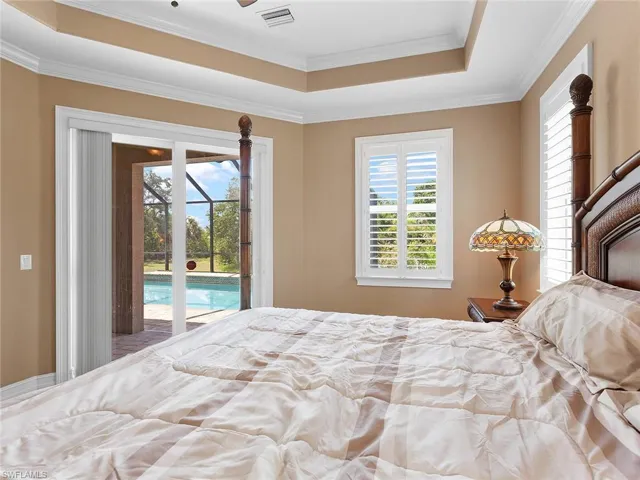 Bedroom featuring access to outside, ornamental molding, a raised ceiling, and visible vents