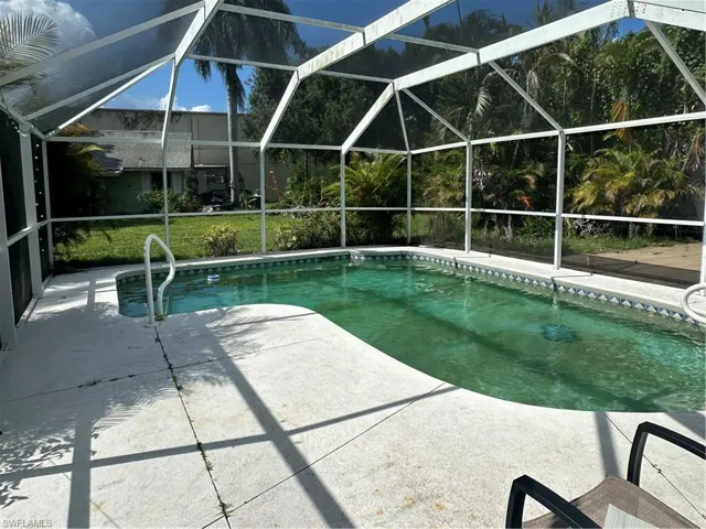 Swimming pool featuring a patio and glass enclosure