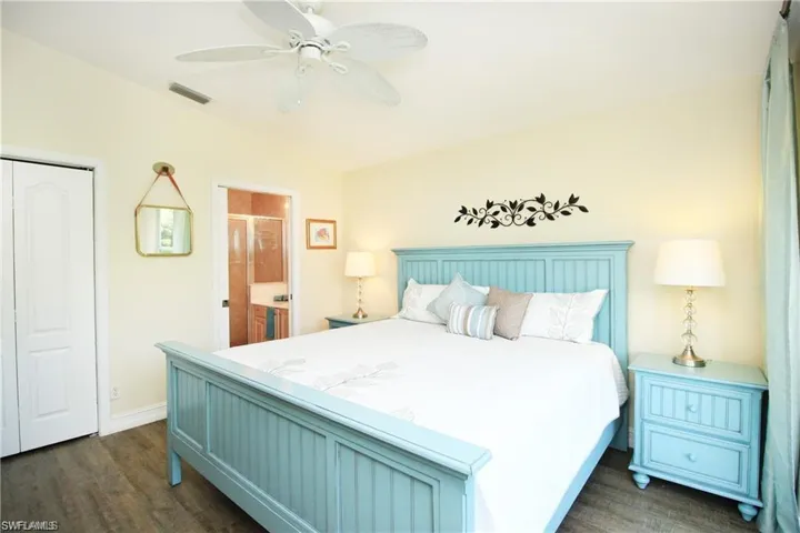 Bedroom featuring ceiling fan, dark hardwood / wood-style floors, a closet, and ensuite bathroom