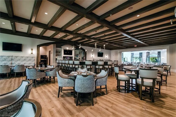 Dining space with light hardwood / wood-style floors, coffered ceiling, and beamed ceiling