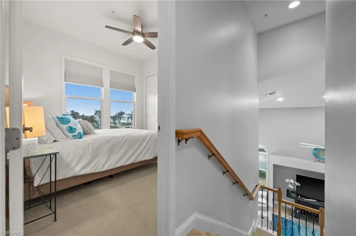 Carpeted bedroom featuring multiple windows and ceiling fan
