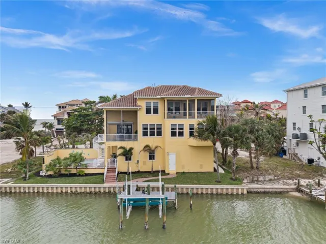Rear view of property featuring a balcony, a sunroom, and a water view