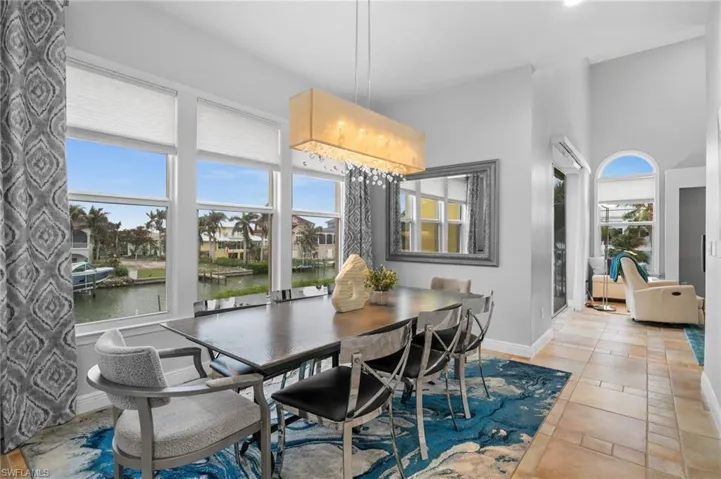 Tiled dining area with a water view and plenty of natural light