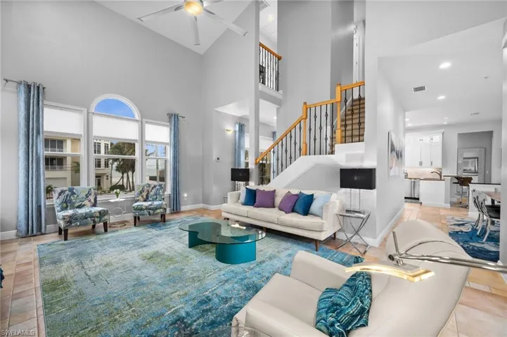 Living room with sink, a towering ceiling, ceiling fan, and light tile patterned flooring