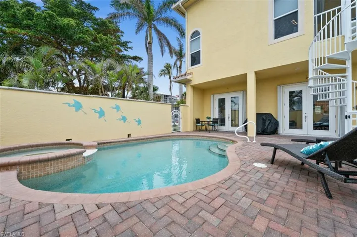 View of pool with an in ground hot tub, french doors, and a patio
