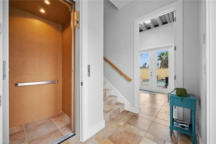 Stairs featuring elevator and french doors
