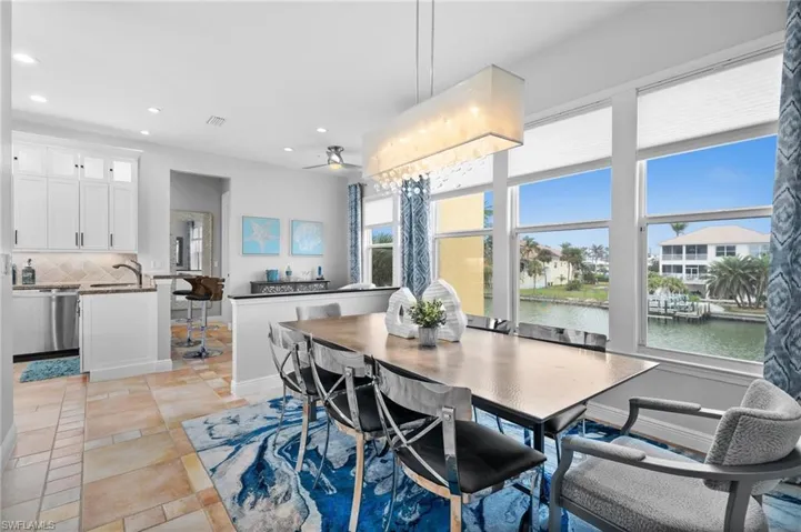 Dining space with sink, a water view, and light tile patterned floors